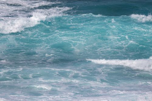 Free Capturing the vibrant blue ocean waves under a clear sunny sky. Ideal for nature and relaxation themes. Stock Photo