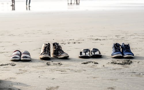 Foto De Diversos Pares De Calçados Na Areia