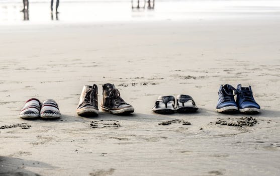 Assorted footwear lined up on the sandy beach of Cox's Bazar, Bangladesh.