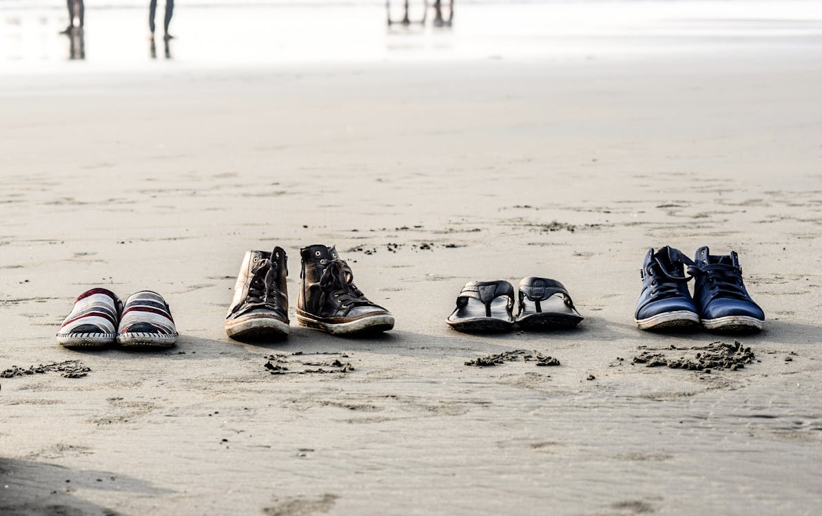 Kum üzerinde çeşitli Ayakkabı çiftleri Fotoğrafı