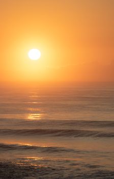 Serene ocean view at golden hour with a dramatic sunset.