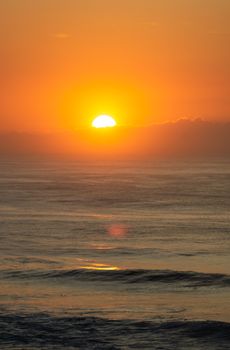 Capture of a vibrant ocean sunset with golden hues and calm waves.