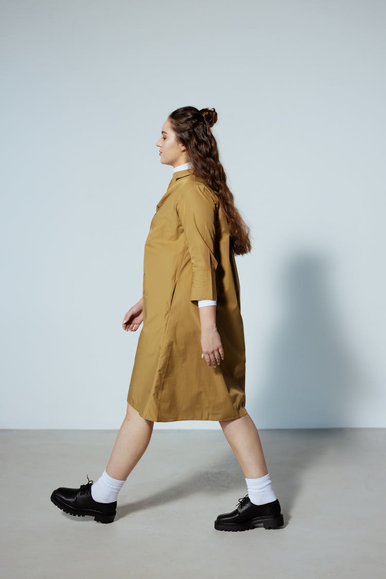 Side View Of A Woman In A Brown Coat Walking 