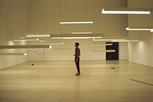 A Man Standing in a Room with Hanging Lights