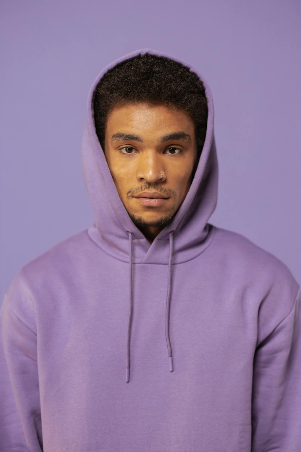Man Wearing His Purple Hoodie on Purple Background · Free Stock Photo