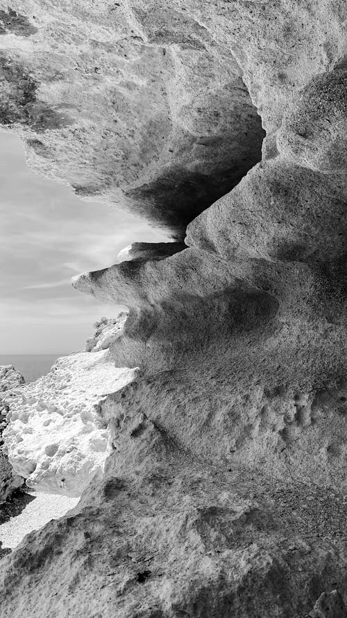 Free Rocky cave on seashore on sunny day Stock Photo