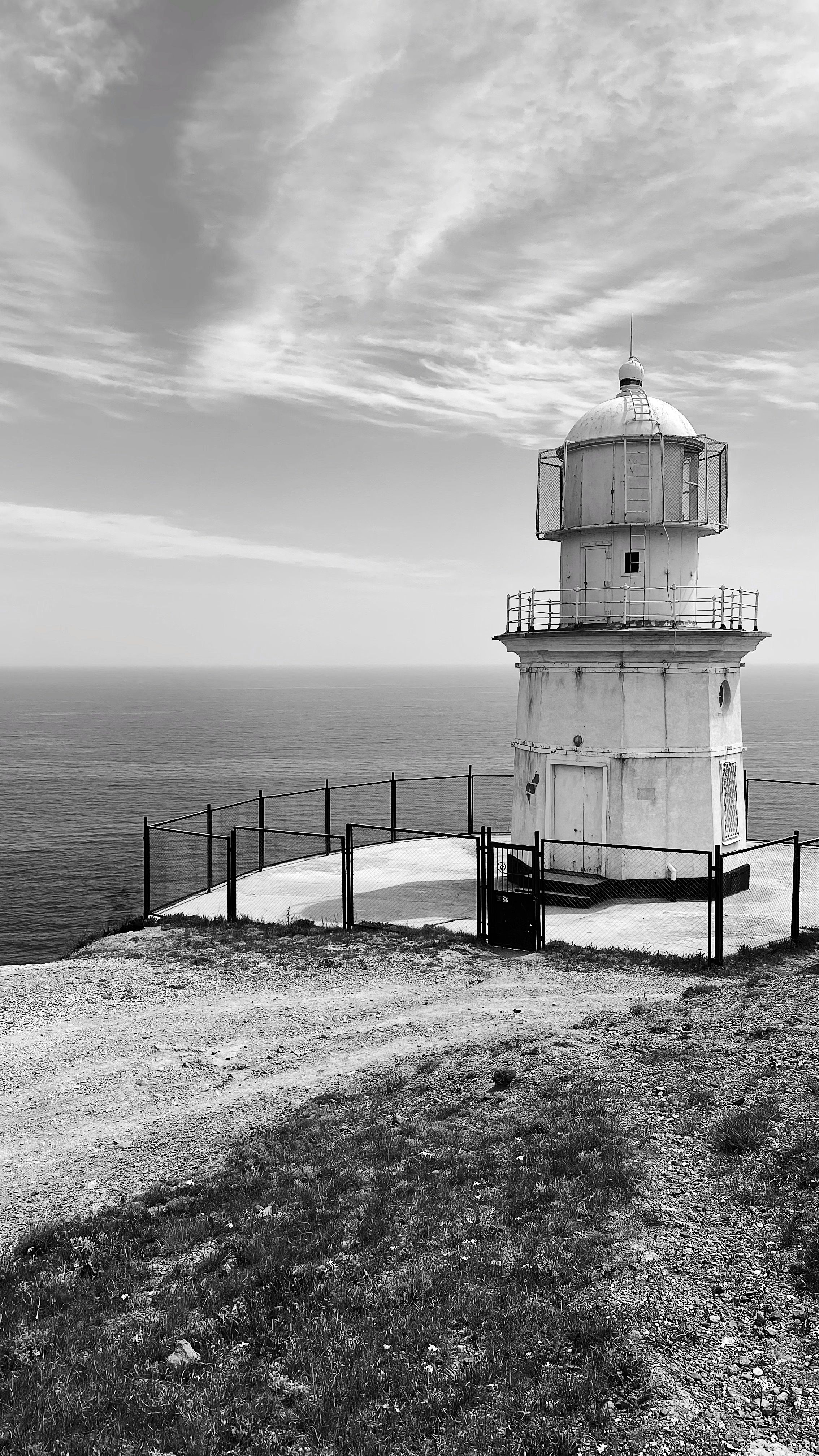 White and Black Lighthouse Near Gray Body of Water · Free Stock Photo