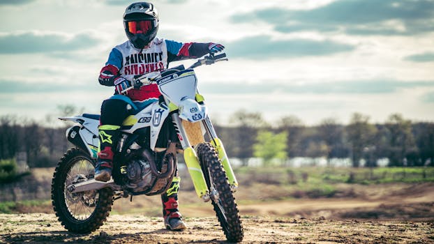 A motocross rider in full gear on a dirt bike, racing outdoors.