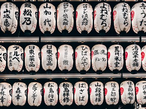 Detailed view of traditional Japanese paper lanterns with kanji characters, creating a cultural ambiance.