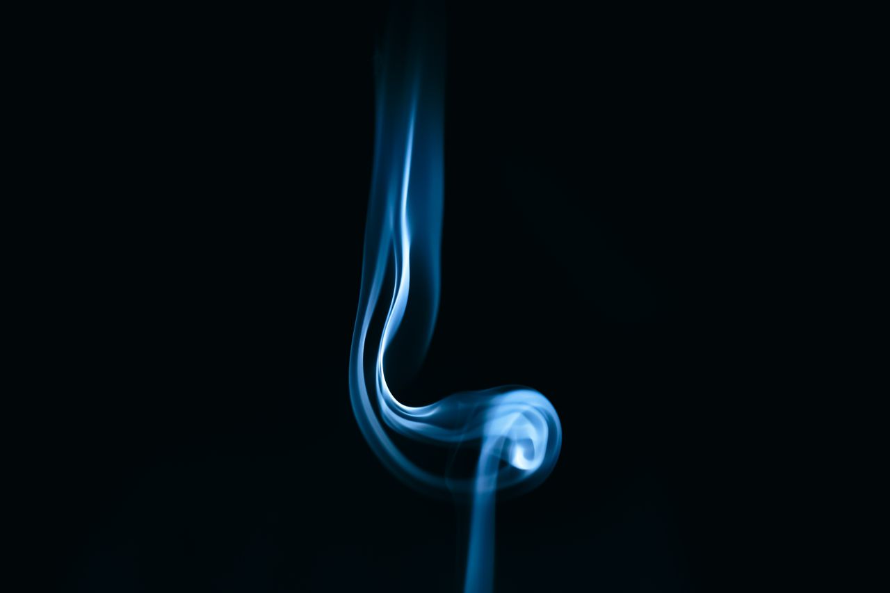 captivating abstract image of blue smoke swirling against a black back