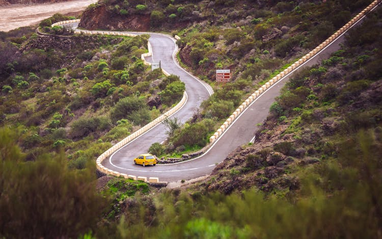 Yellow Car Running On A Curve Road