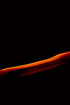 Dynamic abstract image capturing the motion of orange flames against a dark background, creating a vivid sense of movement.
