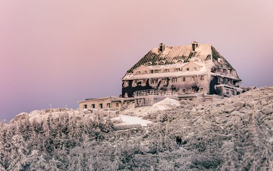 A snowy, frozen building in the winter landscape of Szklarska Poręba, Poland.