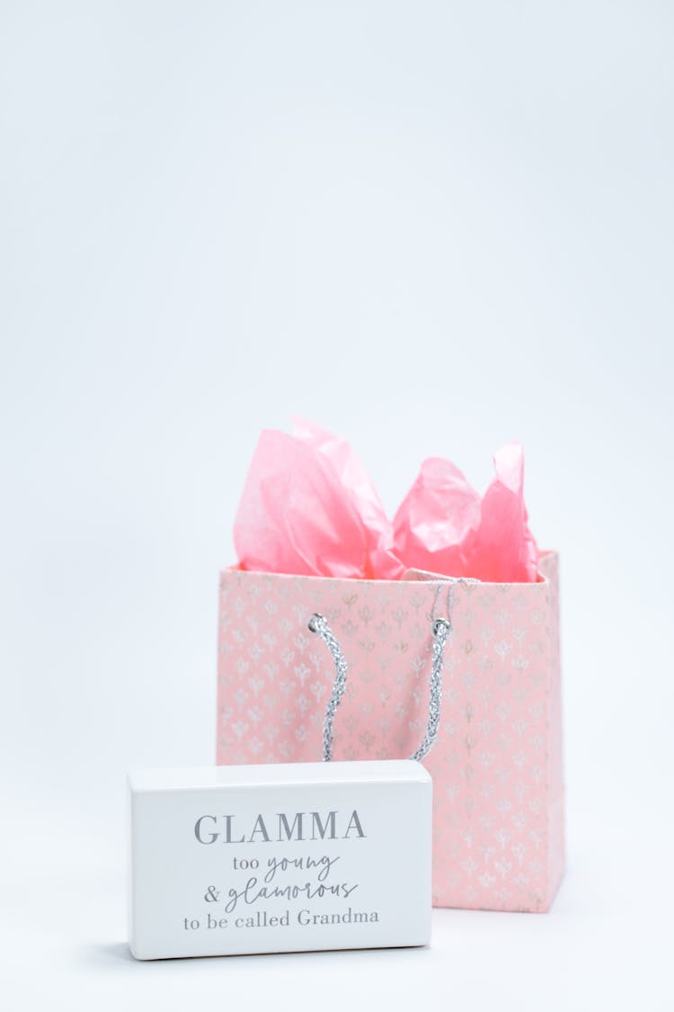 Pink Paper Bag And A Box With Printed Text