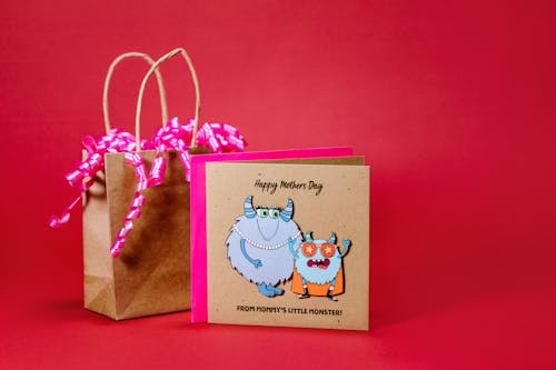 A Greeting Card and Paper Bag on Red Background