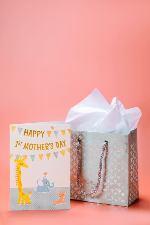 Free A charming card and gift bag set for a first Mother's Day celebration, with cute animal illustrations. Stock Photo