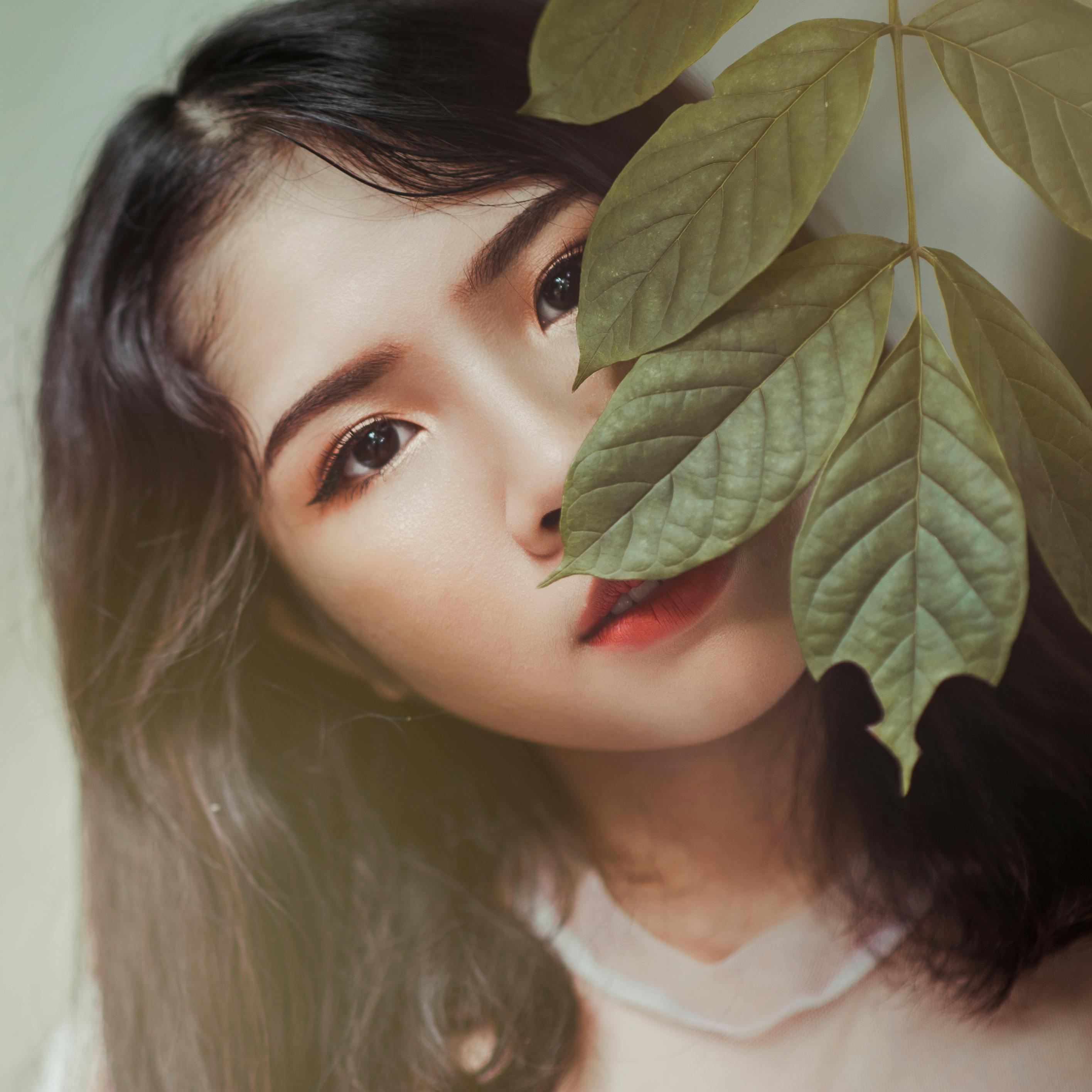 Photography of Brown Haired Woman Near Green Leaves