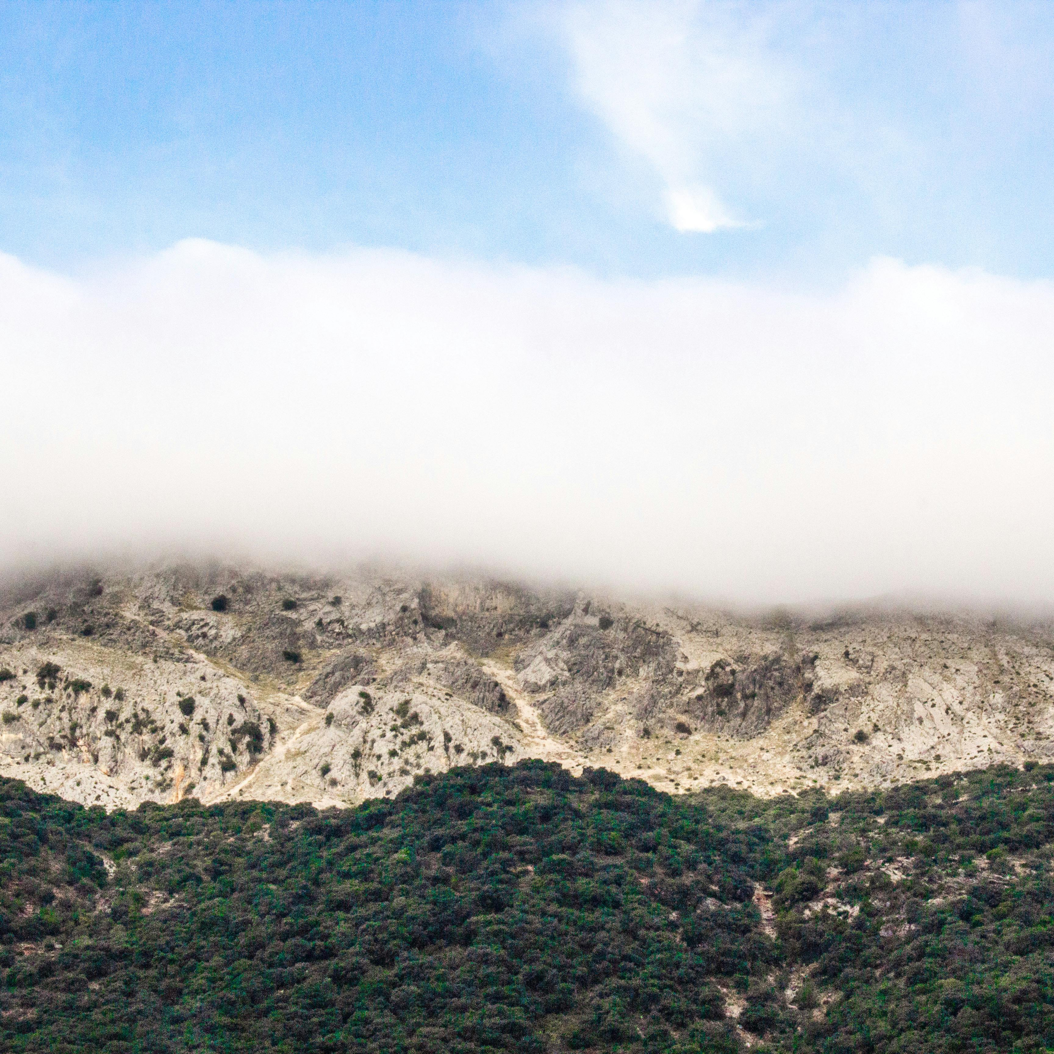 薄雾笼罩的山脉在晴朗的蓝天下，展现了大自然的宁静之美