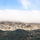 薄雾笼罩的山脉在晴朗的蓝天下，展现了大自然的宁静之美