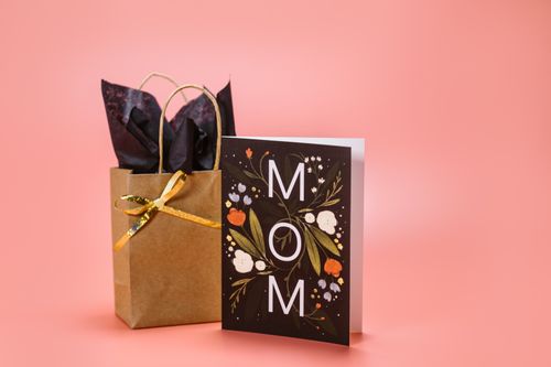 Free A stylish Mother's Day gift bag and card set with floral design on a pink background. Stock Photo