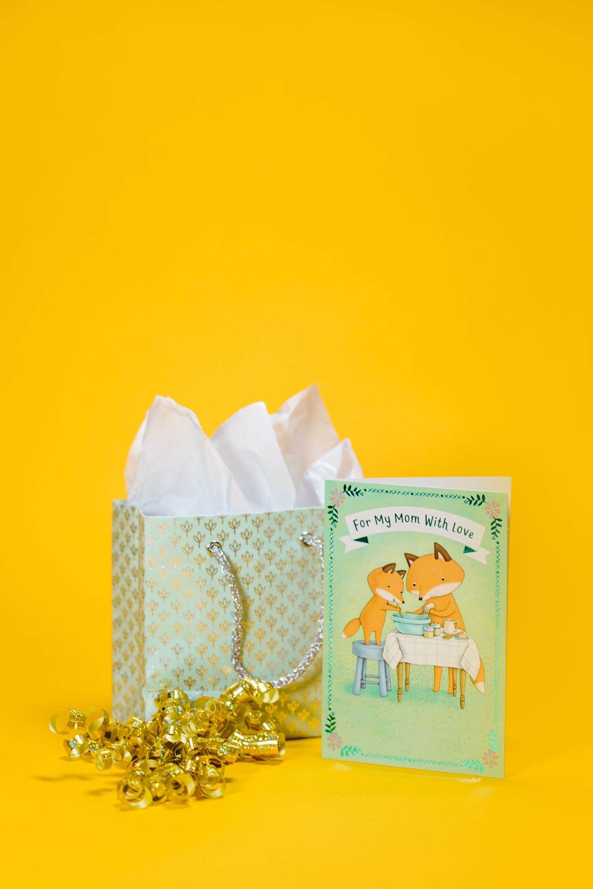 A wrapped gift with a greeting card resting against it