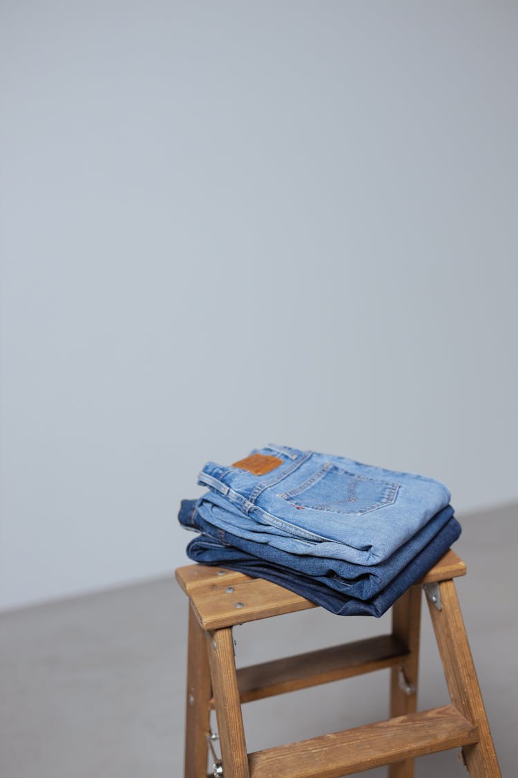 Folded Denim Pants On A Wooden Ladder