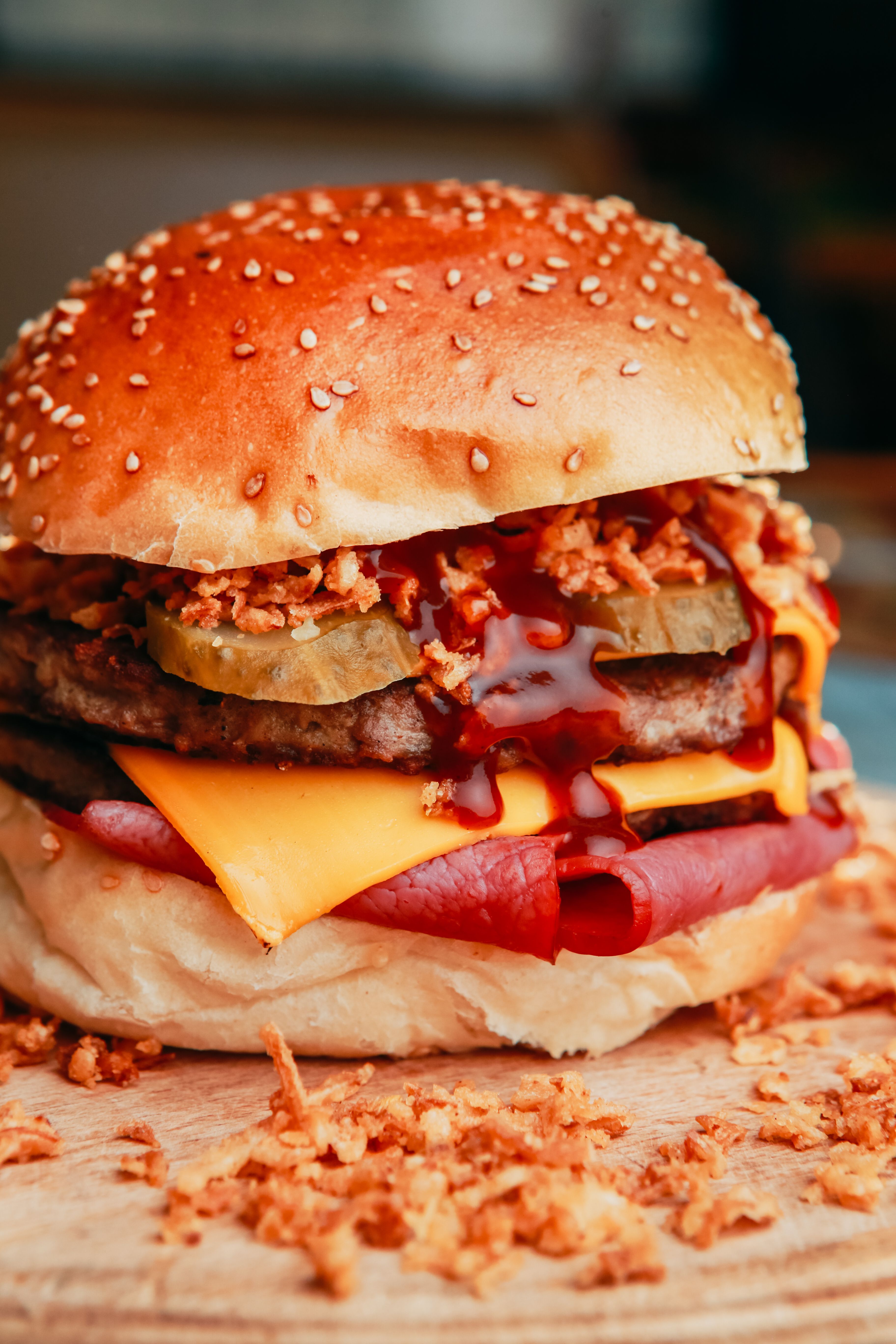 Close-up of a tempting cheeseburger with pickles, cheese, and sauces.