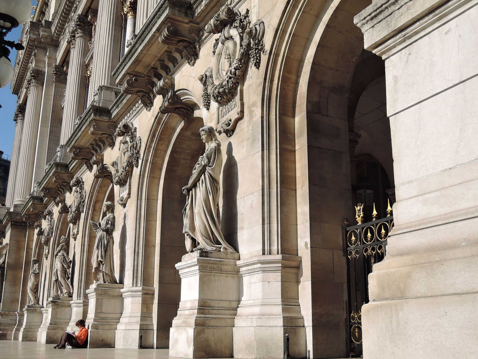 Elegant stone facade with statues and arches in Paris, highlighting classic architectural details.
