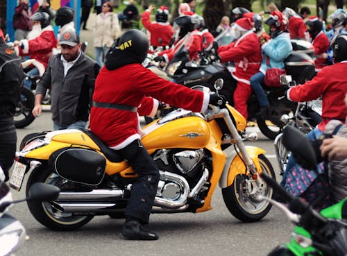 Free Person in Santa Suit Riding Yellow Cruiser Motorcycle Stock Photo