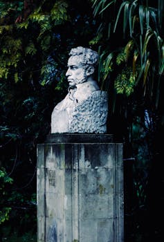 在宁静而郁郁葱葱的公园里，立着一座历史人物的优雅大理石半身像