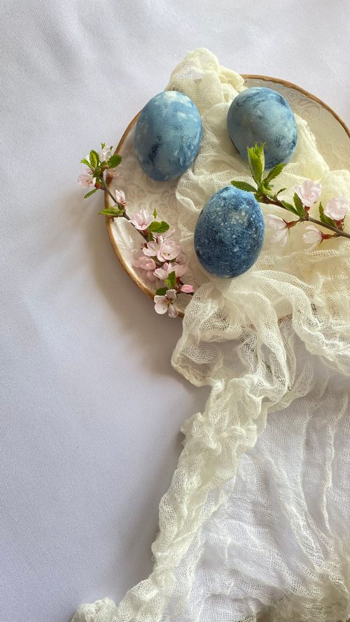 Free Close-up of blue Easter eggs with delicate pink blossoms and white fabric. Stock Photo