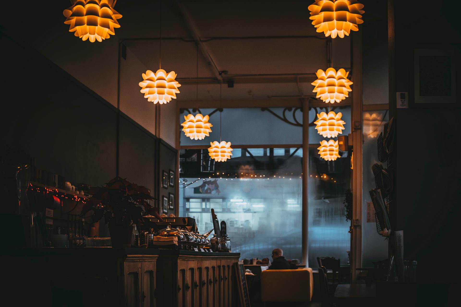 Warm-lit restaurant interior showcasing cozy ambiance and decorative hanging lamps.