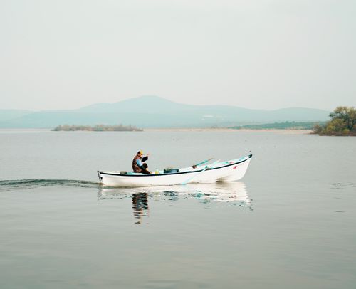 Free Peaceful boat journey across a calm lake in Bursa, Türkiye, amid serene natural scenery. Stock Photo