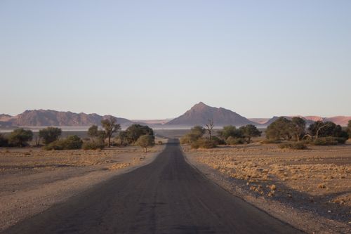 Free Scenic view of a lonely road through Namibia's desert landscape leading to distant mountains. Stock Photo