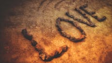 用石头在泥土地上拼出“爱”字的创意设计，展现了自然的纹理