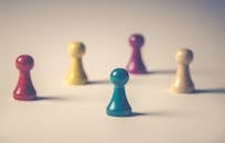 白色表面上，彩色棋盘游戏棋子被创意性地排列成特写