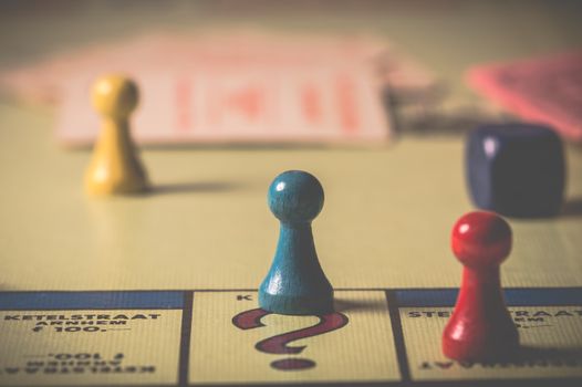 Close-up of a classic board game with vibrant tokens and dice on a playing board.