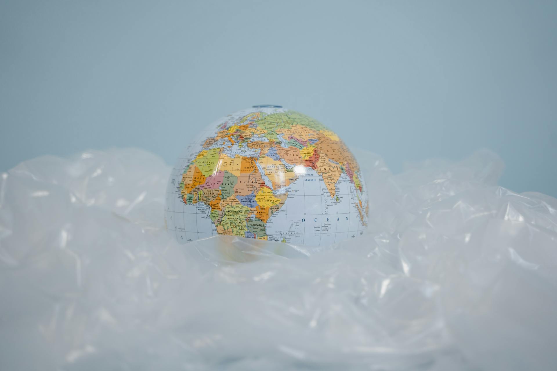 A globe encased in plastic highlighting environmental pollution theme.