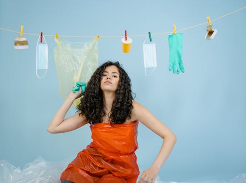 Woman in Red Plastic Dress under Drying Rubbishes on Clothesline