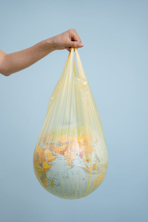 A Person Carrying a Globe in a Plastic Bag