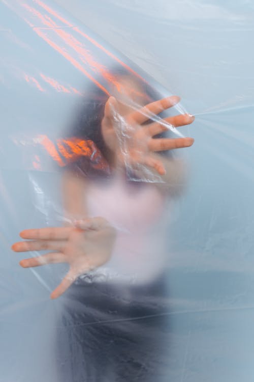 A Person Standing Behind a Plastic Sheet