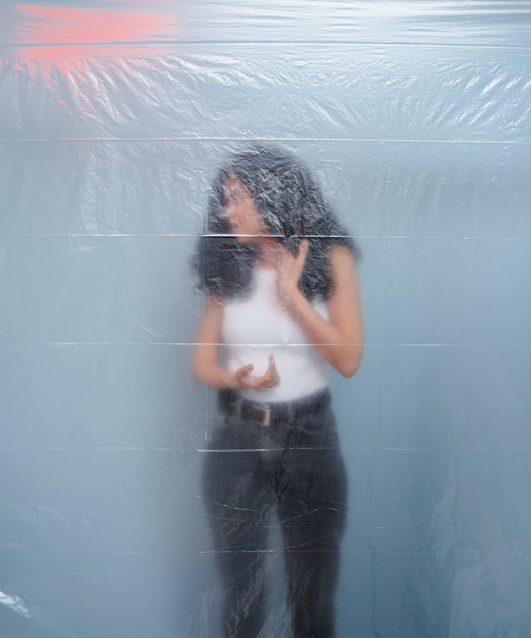 A Woman Standing Behind A Plastic