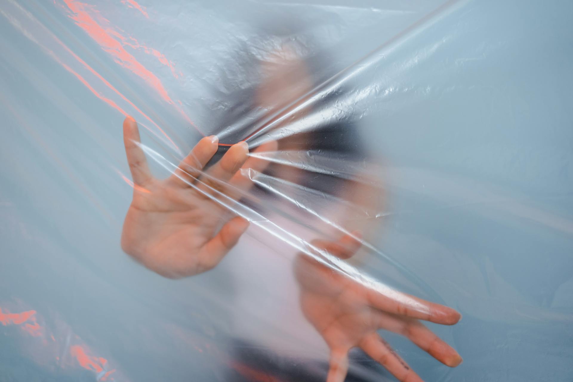 Person Pushing on Plastic Foil