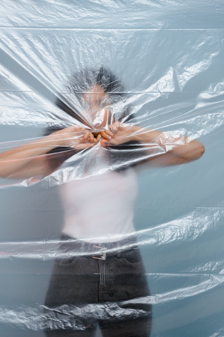 A Woman Standing Behind The Plastic