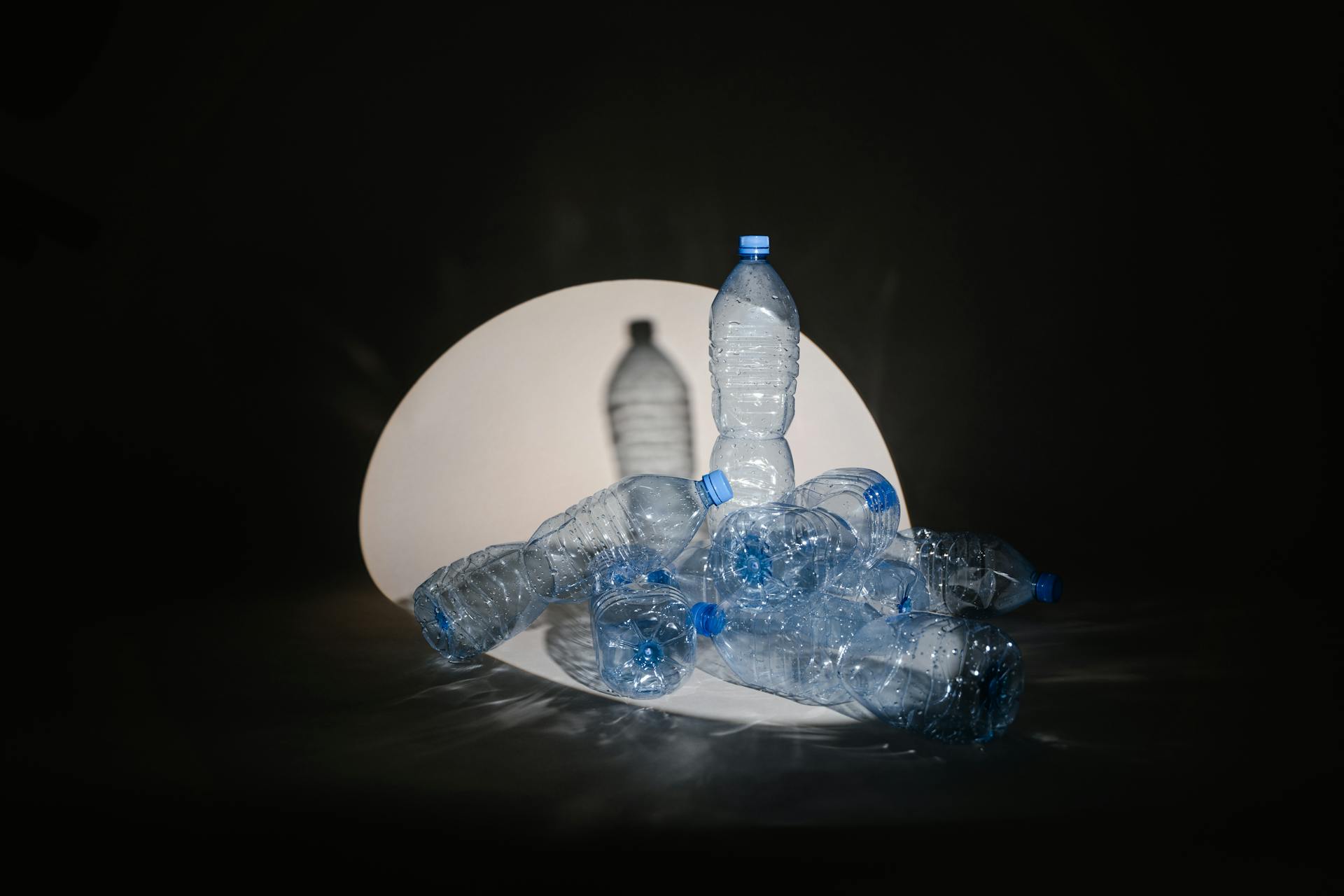 A Spotlight Cast on Plastic Bottles on Black Background