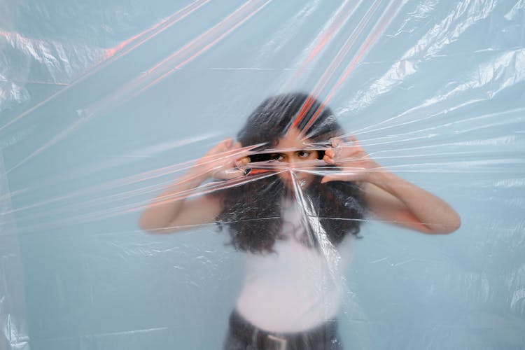 A Woman Tearing A Plastic