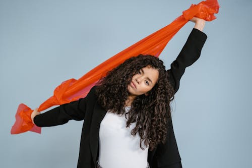 Woman in Black Jacket Stretching Orange Plastic