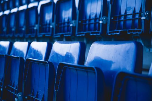 Free Close-up of empty blue stadium seats arranged in a repetitive pattern. Stock Photo
