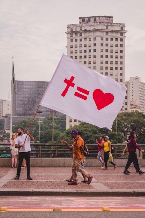 Free Man with Symbolic Flag on City Street Stock Photo
