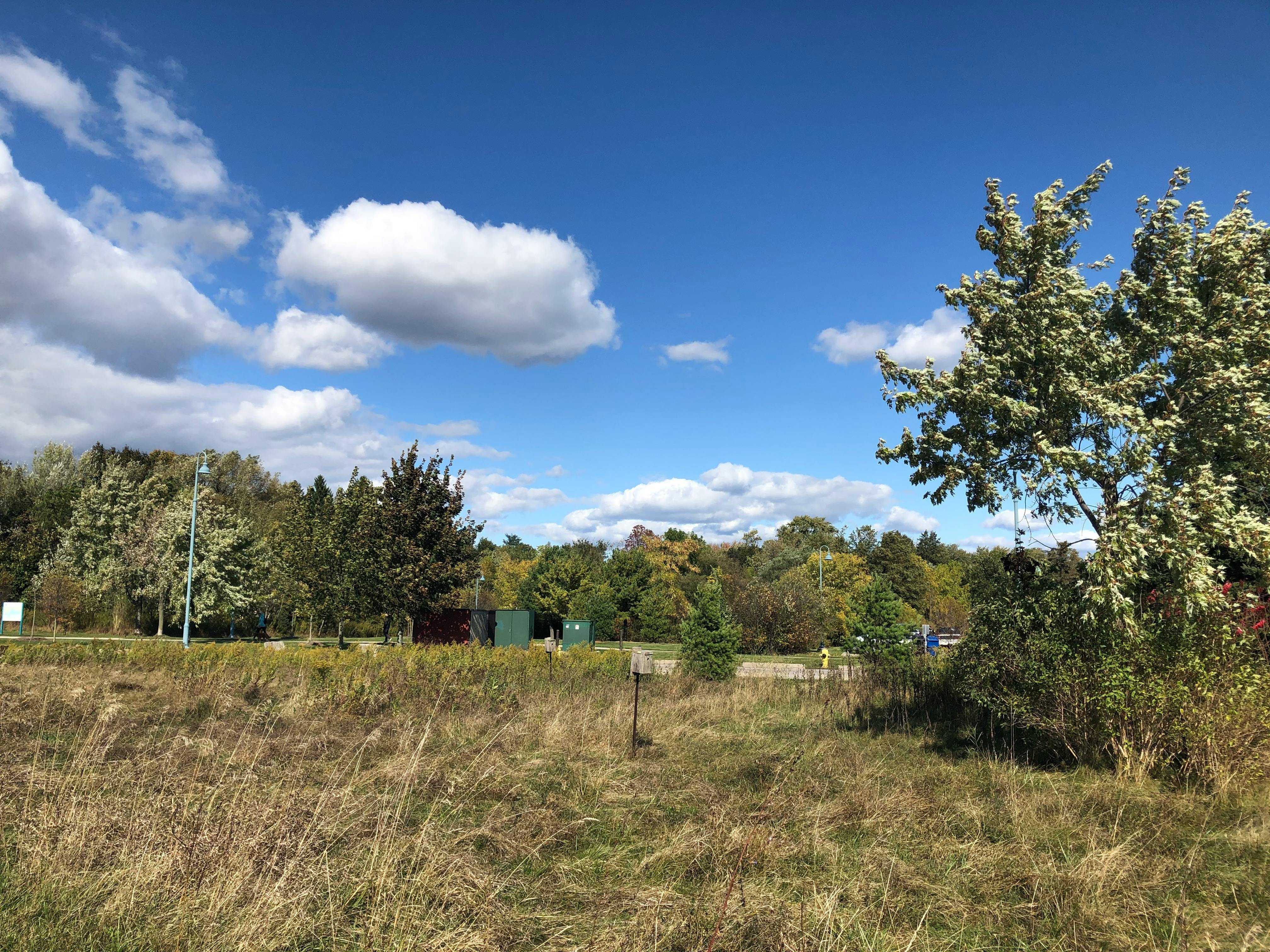 A small, white desktop vacuum cleaner cleaning crumbs from a computer keyboard.